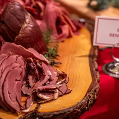 Rökt renkalv på ett rustikt träfat, en del av ett härligt tyrols julbord. Doften av jul sprider sig.