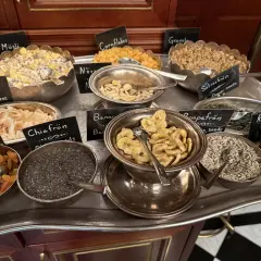 En buffé med olika tillbehör för en härlig **bank hotell brunch**: müsli, nötter, torkad frukt, frön och flingor.