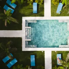 En avkopplande pool med blå solstolar och palmer. En perfekt plats för en resa till Costa Rica.