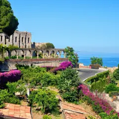 Vacker vy över ruiner och bougainvillea vid havet, en dröm om Sardinien eller Sicilien.