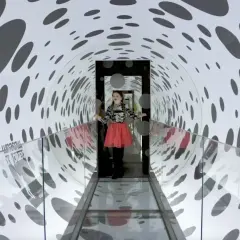 Flicka i en prickig tunnel på Paradox Museum Stockholm, en optisk illusion som leker med perspektiv.