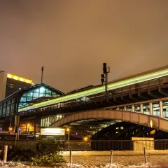 Ett upplyst tåg rusar förbi en station i Berlin, en resa som kan ta dig från Stockholm.