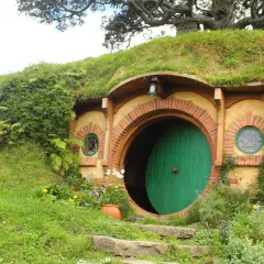 Här är en hobbit-lya, en plats där sagan om ringen spelades in. En stor pumpa ligger i en skottkärra.
