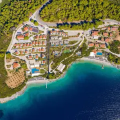 En vy över en ö med röda tak, gröna träd och turkost vatten. En plats som känns som en "mamma mia island" dröm.