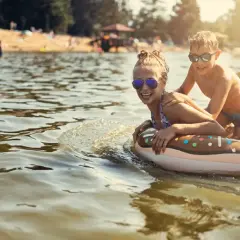 Glada barn på badet i en badort i Tyskland, flyter på en donutring i vattnet.