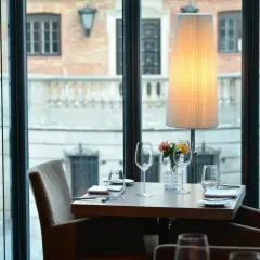 Ett elegant dukat bord med glas och blommor, redo för middag på en av Warszawas restauranger.