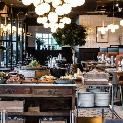 En generös buffé med mat och dryck på restaurang Kolmilan. Vackert dukade bord i bakgrunden.