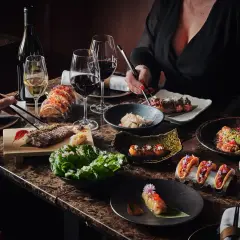Ett lyxigt kasai julbord med biff, sushi, tacos och vin. En festlig måltid att dela.