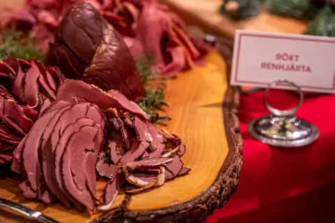Rökt renkalv på ett rustikt träfat, en del av ett härligt tyrols julbord. Doften av jul sprider sig.
