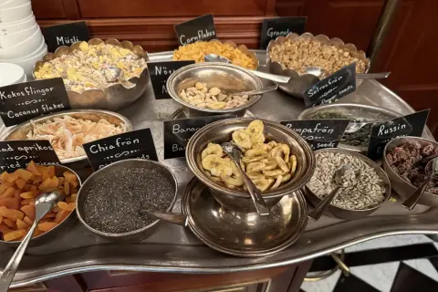 En buffé med olika tillbehör för en härlig **bank hotell brunch**: müsli, nötter, torkad frukt, frön och flingor.