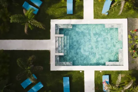 En avkopplande pool med blå solstolar och palmer. En perfekt plats för en resa till Costa Rica.