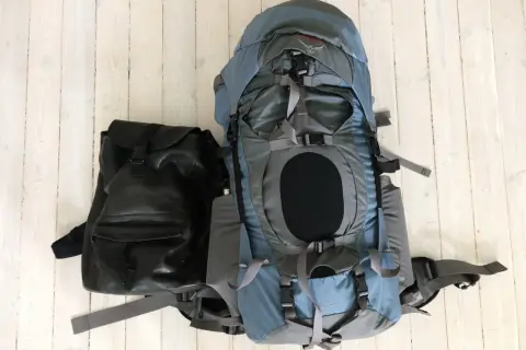 Två ryggsäckar, en stor blå och en mindre svart, redo för en packlista tågluff.