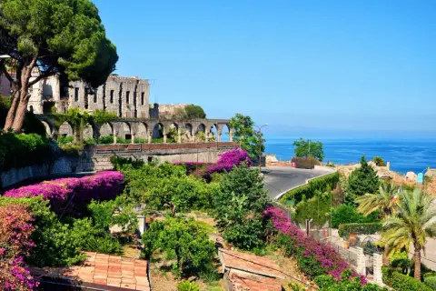 Vacker vy över ruiner och bougainvillea vid havet, en dröm om Sardinien eller Sicilien.