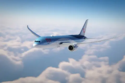 Ett TUI-flygplan flyger över molnen, perfekt för din flyg till Thailand tid.