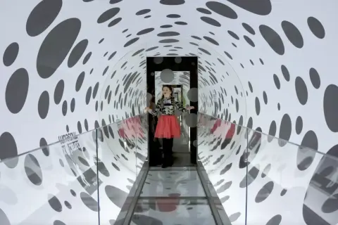 Flicka i en prickig tunnel på Paradox Museum Stockholm, en optisk illusion som leker med perspektiv.