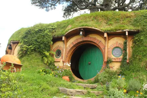 Här är en hobbit-lya, en plats där sagan om ringen spelades in. En stor pumpa ligger i en skottkärra.