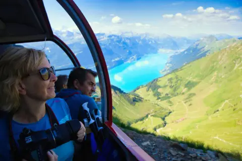 Folk i linbana njuter av alpina vyer. Undrar du vad kostar det att tågluffa i Europa? Denna vy är en del av en fantastisk resa.
