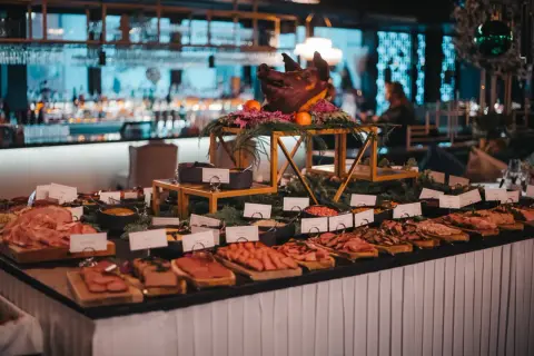 Ett dignande julbord med charkuterier, en dekorerad grisbuk och en bar i bakgrunden. En festlig Mister French julbord-upplevelse.