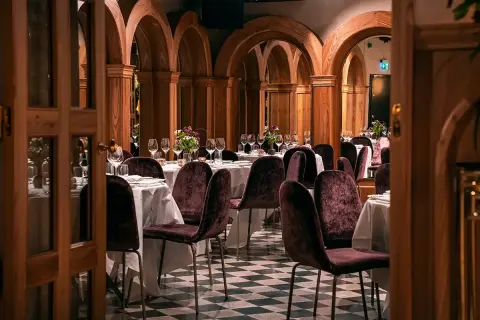 Elegant bank hotel lunch setting with plush chairs and arched wooden decor.