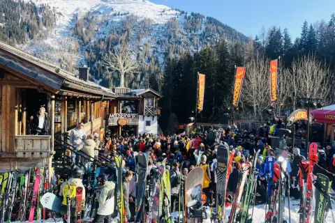 Livligt st Anton afterski med mängder av skidor och folk utanför Mooserwirt. Solig dag i backen.