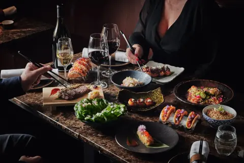 Ett lyxigt kasai julbord med biff, sushi, tacos och vin. En festlig måltid att dela.