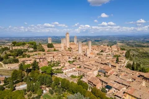 En medeltida stad i Toscana, med sina karakteristiska torn som sträcker sig mot en klarblå himmel.