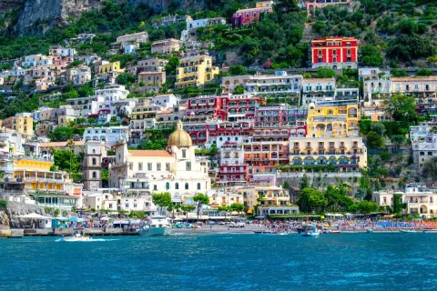 Färgstarka hus klättrar uppför en bergssluttning vid havet, en perfekt vy för en weekend i Italien.
