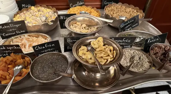 En buffé med olika tillbehör för en härlig **bank hotell brunch**: müsli, nötter, torkad frukt, frön och flingor.