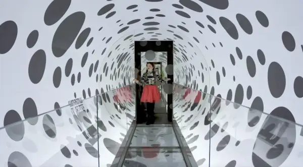 Flicka i en prickig tunnel på Paradox Museum Stockholm, en optisk illusion som leker med perspektiv.