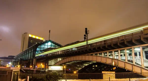 Ett upplyst tåg rusar förbi en station i Berlin, en resa som kan ta dig från Stockholm.