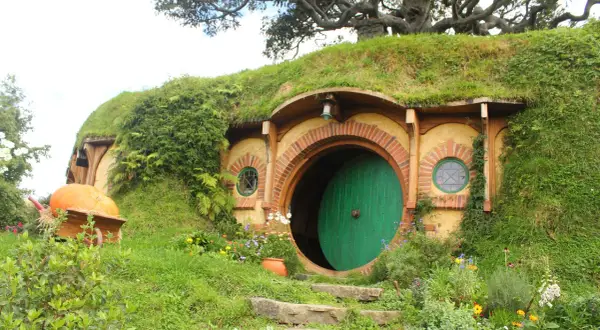 Här är en hobbit-lya, en plats där sagan om ringen spelades in. En stor pumpa ligger i en skottkärra.