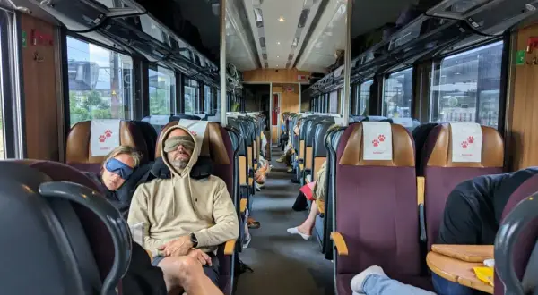 Två personer sover med sovmasker på ett tåg, redo för en lång resa med SJ Euronight.