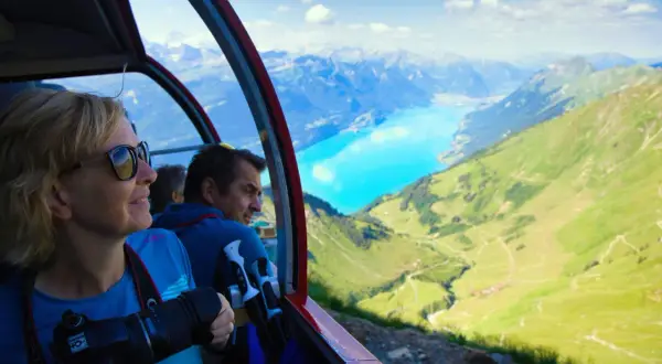 Folk i linbana njuter av alpina vyer. Undrar du vad kostar det att tågluffa i Europa? Denna vy är en del av en fantastisk resa.