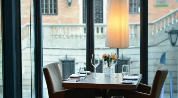 Ett elegant dukat bord med glas och blommor, redo för middag på en av Warszawas restauranger.