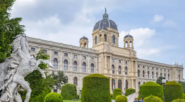 Imponerande byggnad med kupol och en staty av en häst framför. En vacker plats att se i Wien.