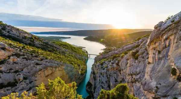 Solnedgång över Gorges du Verdon, med en turkos flod som slingrar sig mellan dramatiska klippor och frodig grönska.