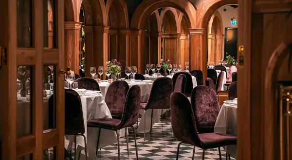 Elegant bank hotel lunch setting with plush chairs and arched wooden decor.