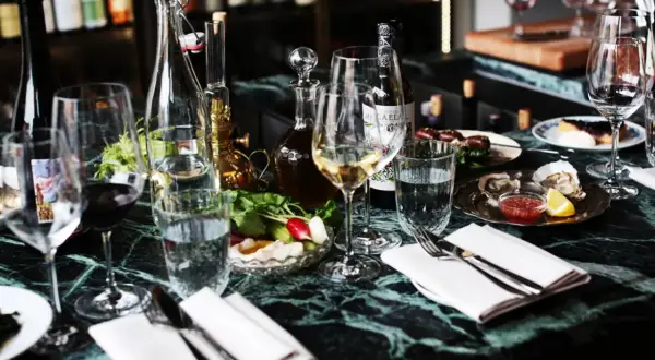 En elegant dukning med glas, flaskor och ostron på ett marmorbord. En härlig kväll på grus grus Odenplan.