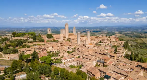 En medeltida stad i Toscana, med sina karakteristiska torn som sträcker sig mot en klarblå himmel.