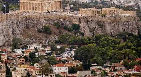 Akropolis reser sig över ett kluster av hus, en påminnelse om historien som finns i restauranger i Aten.