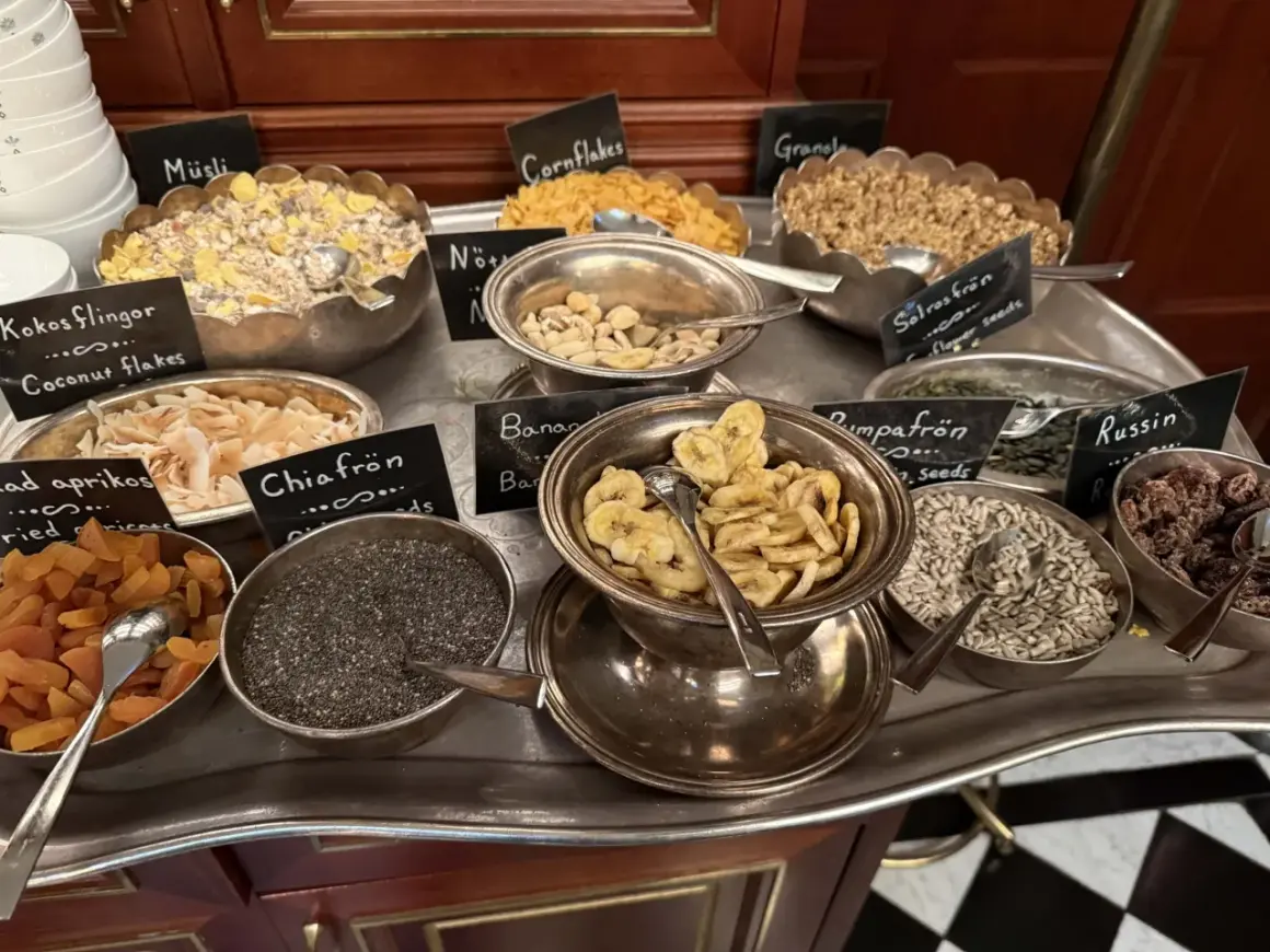 En buffé med olika tillbehör för en härlig **bank hotell brunch**: müsli, nötter, torkad frukt, frön och flingor.
