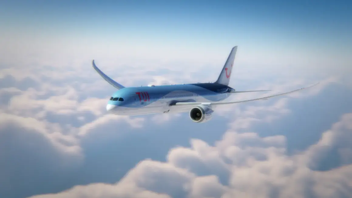 Ett TUI-flygplan flyger över molnen, perfekt för din flyg till Thailand tid.