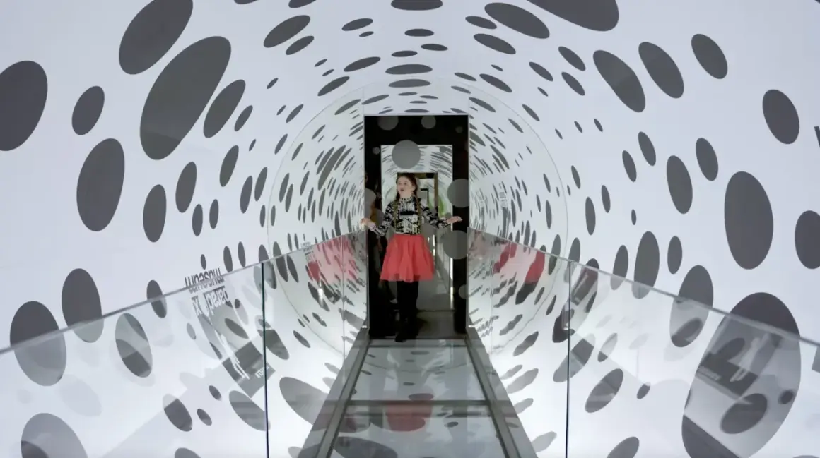 Flicka i en prickig tunnel på Paradox Museum Stockholm, en optisk illusion som leker med perspektiv.
