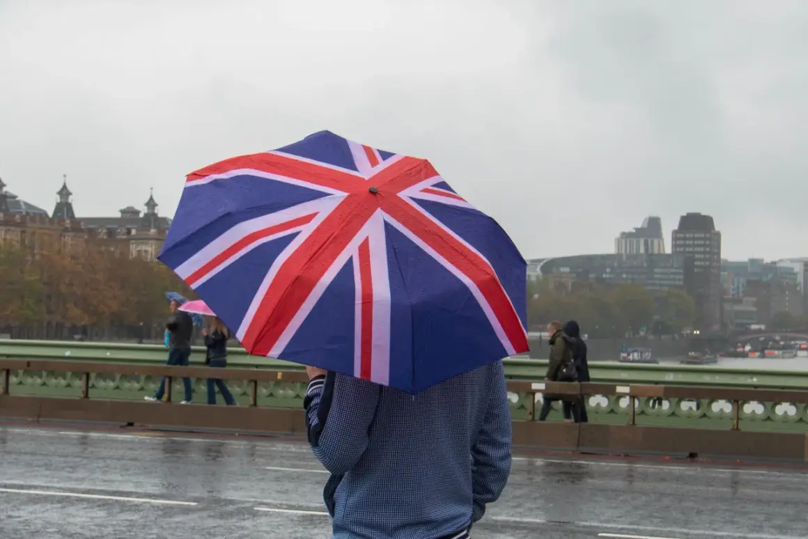 En person med ett paraply med brittiska flaggan på en regnig dag i London. En klassisk vy som visar vad man får inte missa i London.