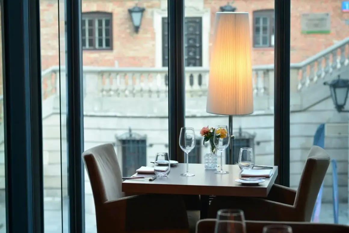 Ett elegant dukat bord med glas och blommor, redo för middag på en av Warszawas restauranger.