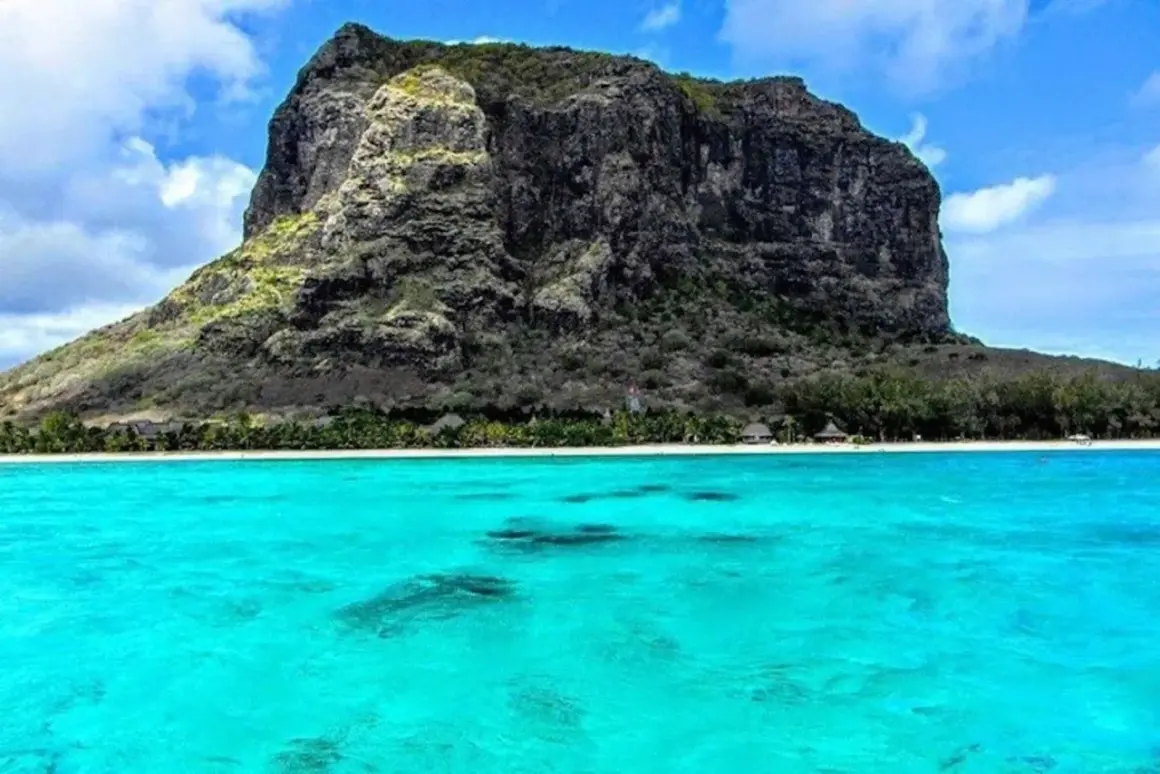 Le Morne Brabant reser sig majestätiskt över turkost vatten och en vit sandstrand. En drömsemester vid havet.