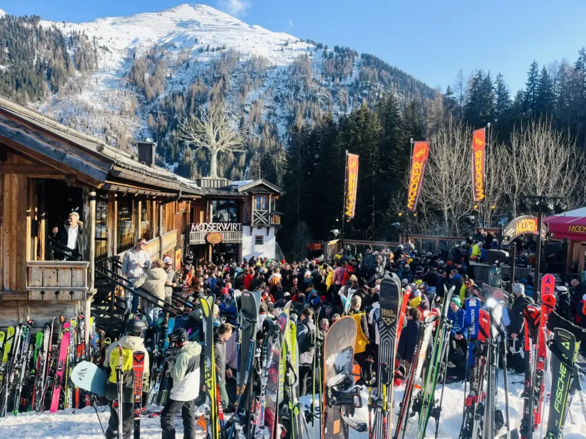 Livligt st Anton afterski med mängder av skidor och folk utanför Mooserwirt. Solig dag i backen.