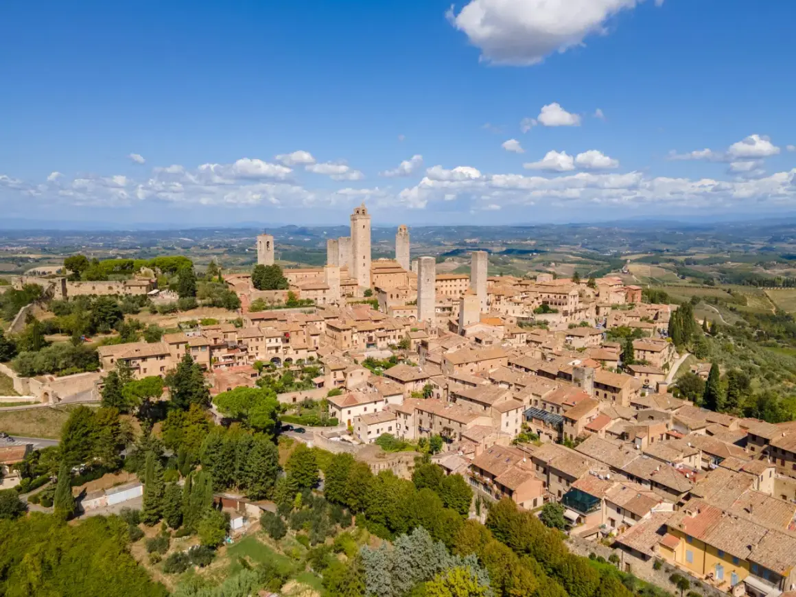 En medeltida stad i Toscana, med sina karakteristiska torn som sträcker sig mot en klarblå himmel.