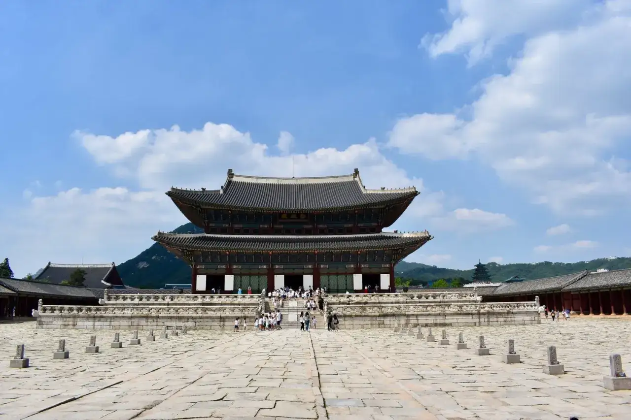 Imponerande palatsbyggnad i Seoul, Sydkorea, med traditionell arkitektur och en stor stenbelagd innergård.