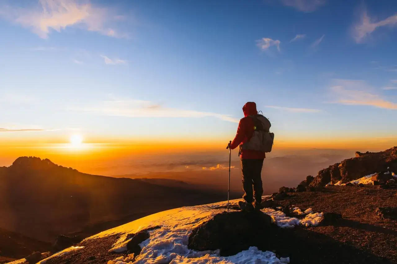 Vandrare på toppen av Kilimanjaro vid soluppgången, en dröm om att bestiga Kilimanjaro blir verklighet.